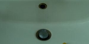 a hand reaching towards a sink